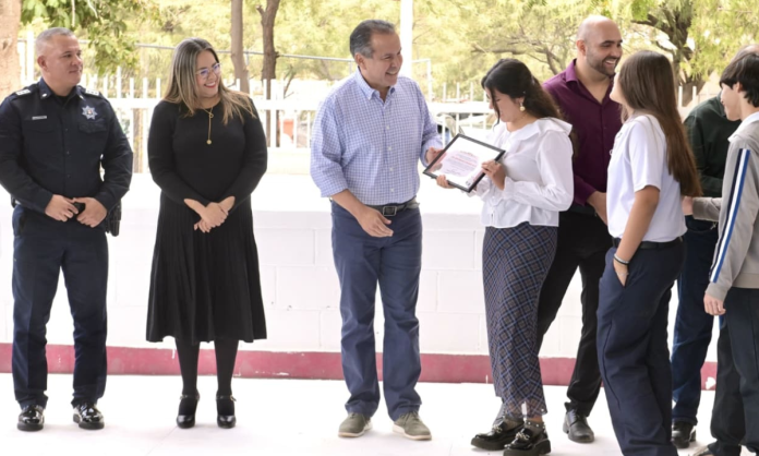 secundaria 9 Reconoce Toño Astiazarán a estudiantes de la secundaria 9 que ganaron concurso de calaveras con material reciclado Lunes 9 de Marzo de 2026 En el marco de la ceremonia de Lunes Cívico en la secundaria 9, arquitecto Gustavo F. Aguilar Beltrán, el Presidente Municipal Antonio Astiazarán Gutiérrez destacó el triunfo del plantel en el concurso de calaveras con material reciclado al que convocó la Dirección de Servicios Públicos Municipales y en el que ganaron de entre 25 escuelas. “Siempre he dicho, queridas amigas y amigos, jóvenes aquí de esta gran escuela secundaria número 9, decirles que el Gobierno solo no puede, que para una ciudad es muy importante que todas y todos entendamos que la ciudad no es otra cosa más que la extensión de nuestra propia casa, y por eso estamos obligados a cuidarla como si fuera nuestro propio hogar”, reflexionó ante alumnado, docentes y directivos de la escuela. Toño Astiazarán encabezó la ceremonia de Lunes Cívico y formalizó la incursión de esta secundaria en el programa Reciclase con la entrega de una estación de reciclaje, un contenedor de 1.3 metros cúbicos de capacidad, 20 arbolitos de especies nativas e insumos para el mantenimiento de las instalaciones. Consideró los encuentros con las comunidades escolares como una gran oportunidad de compartir información sobre acciones del Ayuntamiento para el cuidado del medio ambiente, el impacto positivo logrado con las patrullas eléctricas y que conozcan algunas de las unidades y vehículos utilitarios eléctricos que distinguen a Hermosillo. “Sigamos haciendo ejemplo y que se oiga muy fuerte en toda la H que la secundaria número 9 es la campeona en el reciclaje de nuestra ciudad”, externó luego de entregar a la maestra Ana Isabel Ulloa Álvarez y a sus alumnas y alumnos, su reconocimiento como ganadores del concurso de calaveras hechas con materiales de desecho reciclables. Astiazarán Gutiérrez estuvo acompañado por Jesús Alonso Durón Montaño, Comisario General de la Policía Preventiva y Tránsito Municipal; Sergio Arturo Pavlovich Escalante, director de Servicios Públicos Municipales y David Galván, coordinador de zona del programa CRECES. Los recibieron Jorge Luis González Fimbres y Cora Patricia Mora, director y directora de la escuela respectivamente y Fausto Blanco Dávalos supervisor de zona escolar y como invitadas acudieron las regidoras Dulce Robles y Carla Salcido. Previo a la ceremonia cívica, las botargas UMPI de Bomberos de Hermosillo; Tina Gotina, de Agua de Hermosillo y Reciclara, de Servicios Públicos Municipales, saludaron a las alumnas y alumnos y amenizaron la ocasión con bailes y expresiones de camaradería.